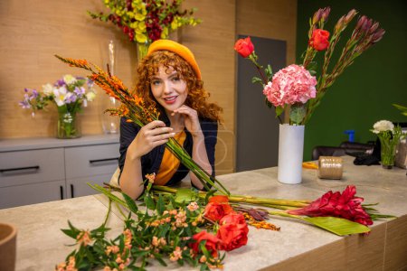 Photo for Romantic young girl. Ginger long-haired girl with flowers looking romantic - Royalty Free Image