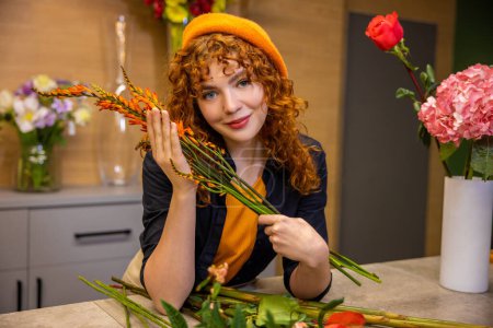Photo for Romantic young girl. Ginger long-haired girl with flowers looking romantic - Royalty Free Image