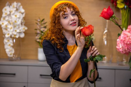 Photo for Flower shop. Young ginger girl in beret in a flower shop - Royalty Free Image