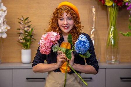 Photo for Young florist. Young florist in a flower shop dealing with flowers - Royalty Free Image