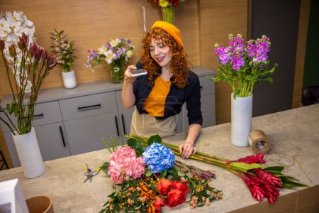 Téléchargez les photos : Jeune fleuriste. Jeune fleuriste dans un magasin de fleurs traitant de fleurs - en image libre de droit