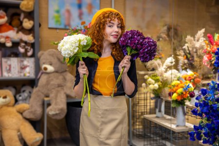 Foto de En una florería. Linda chica sonriente con flores buscando disfrutado - Imagen libre de derechos