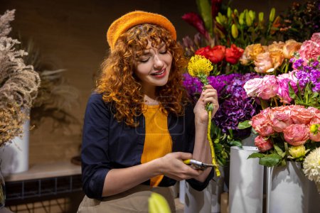 Foto de Florista en el trabajo. Bonita floristería ordenando las flores y buscando involucrado - Imagen libre de derechos