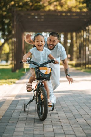 Foto de Montar en bicicleta. Feliz niña montando una bicicleta y mirando emocionado - Imagen libre de derechos