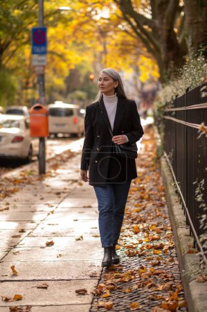 Téléchargez les photos : Automne. Jolie femme mature marchant dans le parc d'automne - en image libre de droit