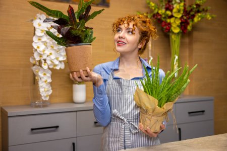 Photo for Flower shop. Ginger young florist in a flower shop - Royalty Free Image