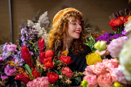 Foto de Floristería. Sonriente joven bonita en una floristería - Imagen libre de derechos