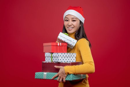 Photo for Xmas gifts. Young cute woman carrying boxes of xmas presents - Royalty Free Image