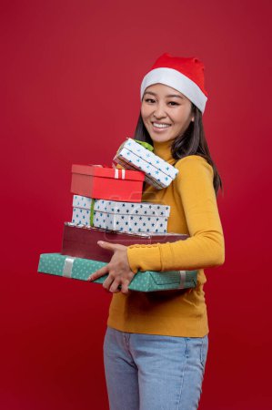 Foto de Regalos de Navidad. Joven linda mujer llevando cajas de regalos de Navidad - Imagen libre de derechos
