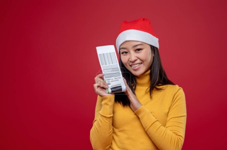 Téléchargez les photos : Joyeux Noël. Femme mignonne dans le chapeau de Père Noël regardant excité et heureux - en image libre de droit