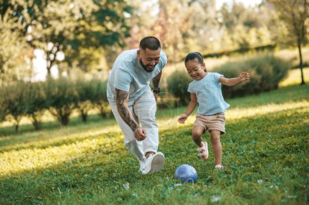 Photo for Football. Young man playing football with his daughter in the park - Royalty Free Image