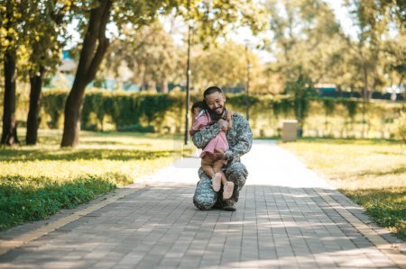 Photo for Happy meeting. Little girl looking happy while hugging her dad after long parting - Royalty Free Image