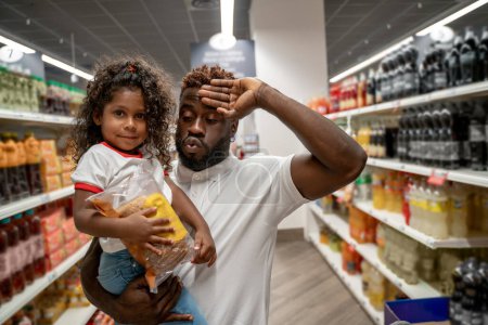 Téléchargez les photos : Supermarché. Homme et sa fille dans un supermarché faisant du shopping - en image libre de droit