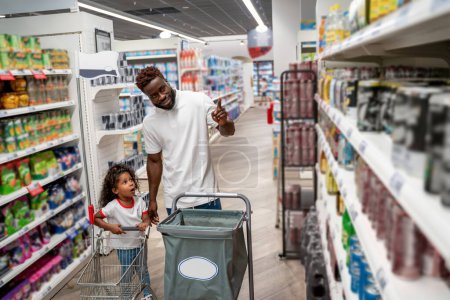 Foto de En un supermercado. Niña y su padre en un supermercado - Imagen libre de derechos
