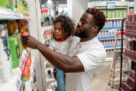 Téléchargez les photos : Dans un supermarché. Petite fille et son père dans un supermarché - en image libre de droit