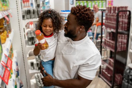 Téléchargez les photos : Dans un supermarché. Petite fille et son père dans un supermarché - en image libre de droit
