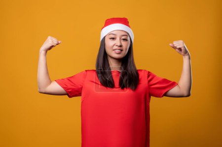 Photo for Determined. Cute young woman in red showing her muscles and looking determined - Royalty Free Image