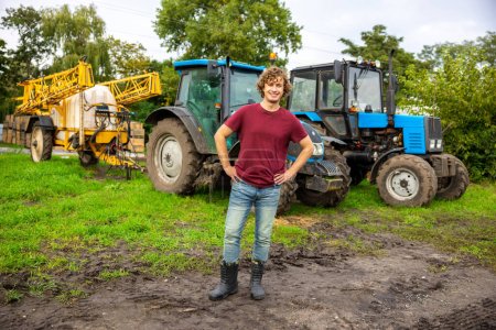 Photo for Full-length portrait of a smiling cheerful young worker posing for the camera on the agricultural machinery - Royalty Free Image