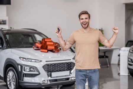 Photo for New car. Happy and excited new car owner in a car salon - Royalty Free Image