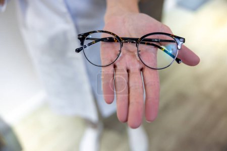 Foto de Cuidado de los ojos. Primer plano de las manos de las hembras con gafas y lentes - Imagen libre de derechos