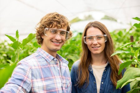 Photo for Cheerful agronomist and his joyous female colleague taking selfies among vegetable crops in the hothouse - Royalty Free Image
