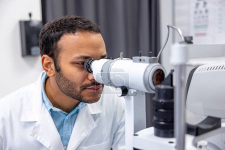 Photo for Optometry. Male doctor working on optometric equipment at clinic - Royalty Free Image