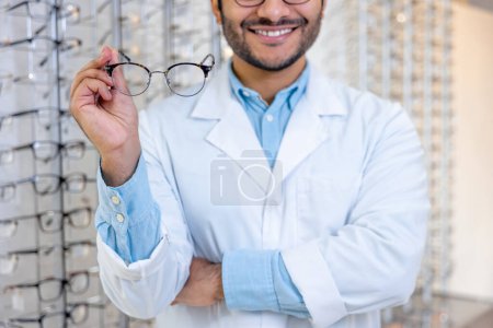 Photo for Eyeglasses. Man in a lab coat holding eyeglasses in hands - Royalty Free Image