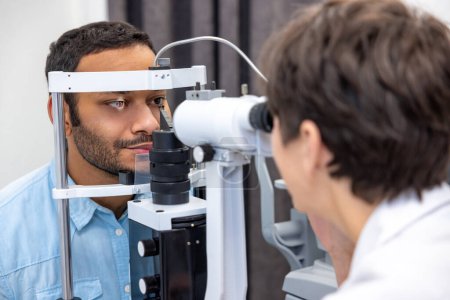 Photo for At the doctors. Female doctor examining patients eyes on the optometric equipment - Royalty Free Image