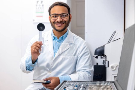 Photo for Positive doctor. Ophtalmologyst in lab coat looking positive and smiling - Royalty Free Image