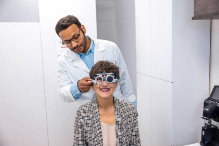 Photo for Examining the patient. Optometrist examining a patient at the clinic - Royalty Free Image