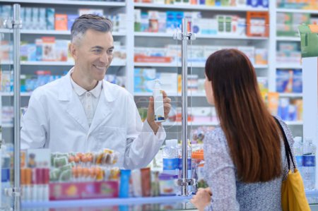 Téléchargez les photos : At the drugstore. Long-haired woman buying medicines in the drugstore - en image libre de droit
