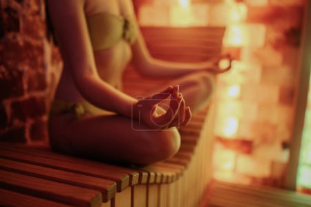 Foto de Meditation. Woman sitting in a lotus pose and meditationg - Imagen libre de derechos