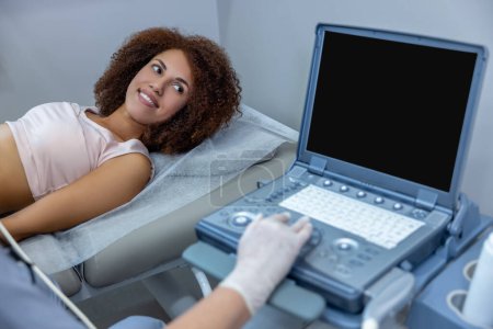 Photo for Ultrasonography. Gynecologist doing ultrasonography to a pregnant woman - Royalty Free Image