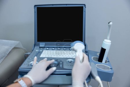 Téléchargez les photos : Ultrasonography. Close up of doctors hand on ultrasonography apparatus - en image libre de droit