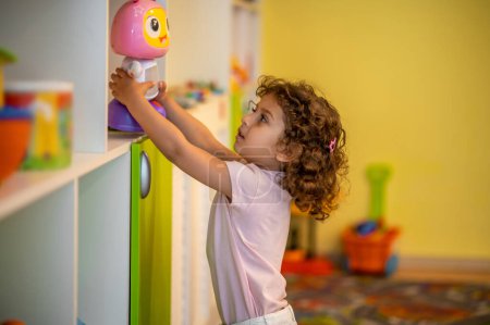 Foto de Playing. Cute little girl playing in a play room and looking interested - Imagen libre de derechos