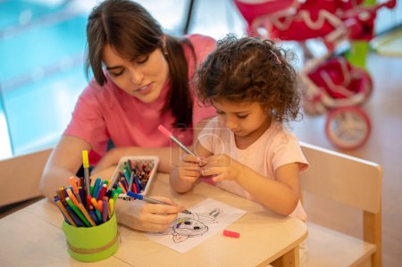 Photo for Arts. Mom and her daughter spending time in a play room drawing - Royalty Free Image