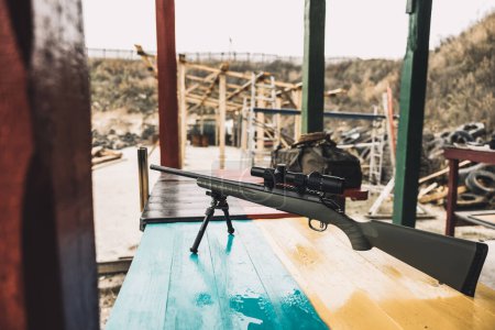 Photo for Military camp. Rifle on a table with ukrainian flag - Royalty Free Image