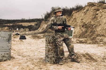 Téléchargez les photos : On a shooting range. Mature bearded soldier on a shooting range - en image libre de droit