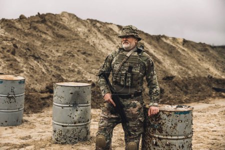 Foto de On a shooting range. Mature bearded soldier on a shooting range - Imagen libre de derechos