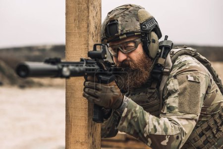 Téléchargez les photos : Shooting. Bearded sniper with optical rifle shooting - en image libre de droit
