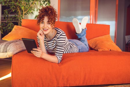Photo for Leisure. Ginger girl looking relaxed spending time online - Royalty Free Image