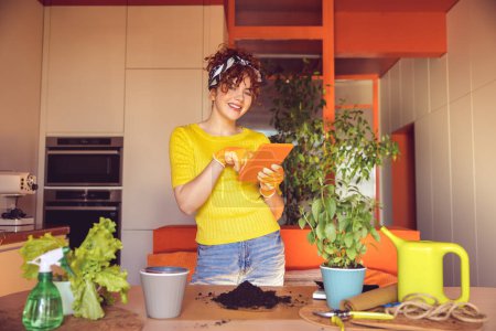 Téléchargez les photos : Home gardening. Cute merry young girl making home gardening works - en image libre de droit