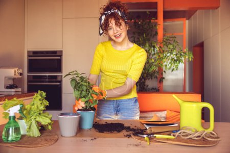 Photo for Home gardening. Cute merry young girl making home gardening works - Royalty Free Image