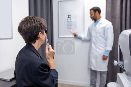 Photo for Eyesight check up. Short-haired mid aged woman having an eyesight check - Royalty Free Image