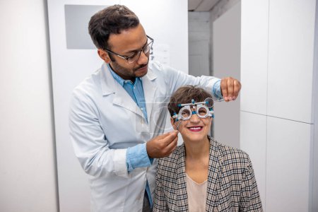 Foto de Eyesight check. Male optometrist checking eyesight of a female visitor - Imagen libre de derechos