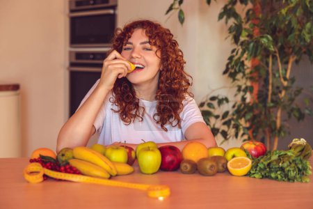 Téléchargez les photos : Fruits. Long-haired cute girl at the table with many fruits - en image libre de droit