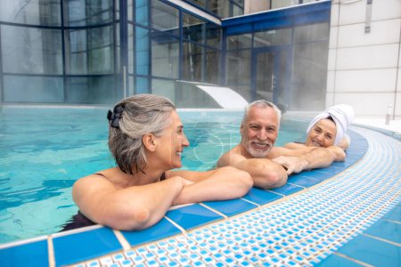 Téléchargez les photos : Relaxed. Seniors spending a day at the swimming pool nad looking relaxed - en image libre de droit