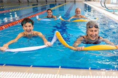 Photo for Water fitness class. Group of people working with float noodles at water fitness class - Royalty Free Image
