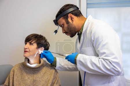 Foto de Checkup. ENT doctor examinine patients ear with endoscope - Imagen libre de derechos
