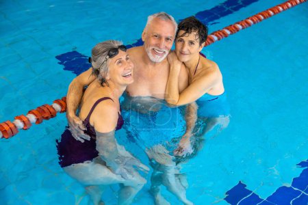 Foto de Healthy lifestyle. Group of seniors at the swimming pool looking happy and enjoyed - Imagen libre de derechos